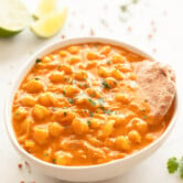 Photo of a bowl of homemade chickpea curry served with some bread