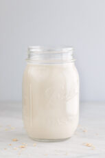 一个装着自制燕麦牛奶的玻璃罐子的侧面照片