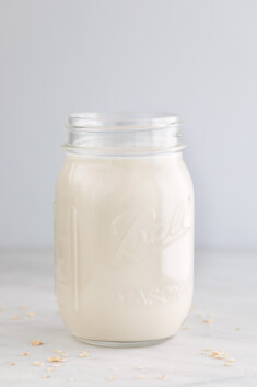 一个装着自制燕麦牛奶的玻璃罐子的侧面照片