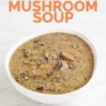一碗素食奶油蘑菇汤的图片放在大理石表面上，上面写着素食奶油蘑菇汤