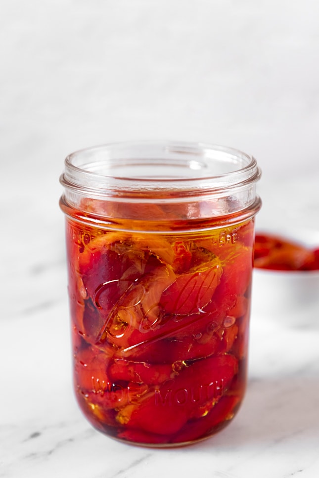 一个玻璃罐和一些烤红辣椒的照片